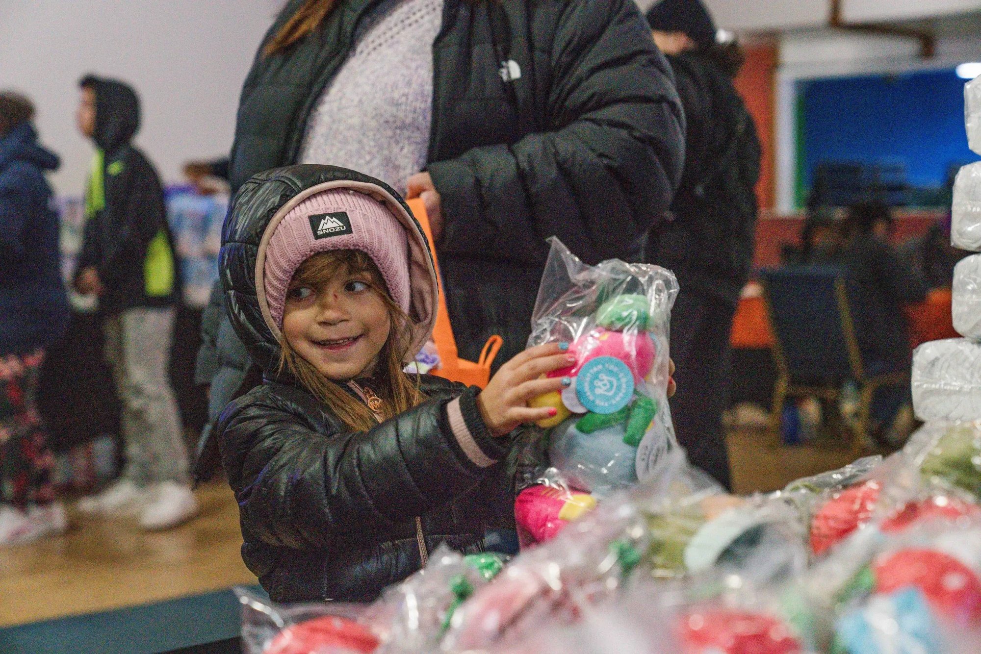 A smiling child receives donated product A smiling child receives donated product